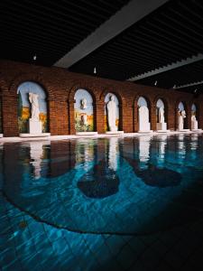 a large pool of water in a building with statues at Fini-Resort Badenweiler in Badenweiler