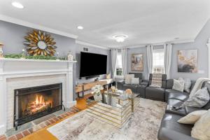 a living room with a fireplace and a tv at Barnstable Luxury Family Retreat with pool, fire pit and beach nearby in Barnstable