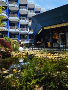 ein Gebäude mit einem Teich vor einem Gebäude in der Unterkunft Fini-Resort Badenweiler in Badenweiler