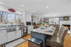 a kitchen with white cabinets and a large island at Barnstable Luxury Family Retreat with pool, fire pit and beach nearby in Barnstable