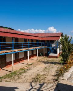 Mahānkāl的住宿－Sindhu Organic Agro And Farmstay，一座红色屋顶和蓝色装饰的建筑