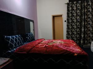 Un dormitorio con una cama con una manta roja. en Hotel Moon Light view, en Lahore