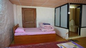 a small room with a bed and a window at Sindhu Organic Agro And Farmstay in Mahānkāl