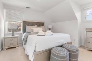 um quarto branco com uma cama grande e uma janela em Colonial Vacation Home w Private Pool fire pit and spacious backyard em Falmouth