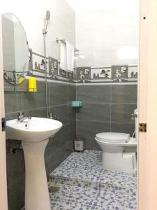 een badkamer met een wastafel, een toilet en een spiegel bij Nhà nghỉ Nam Anh in Can Tho