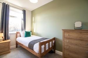 een slaapkamer met een bed, een raam en een dressoir bij Charming Middlesbrough Home in Middlesbrough