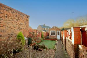 een achtertuin met een stenen muur en een tuin bij Charming Middlesbrough Home in Middlesbrough