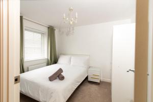 a bedroom with a white bed with a brown object on it at Cosy Home with Garden in a Picturesque Village in Hull