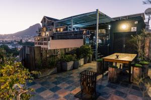 eine Dachterrasse mit einem Tisch und einem Gebäude in der Unterkunft Cape Diamond Boutique Hotel in Kapstadt