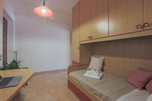 een kamer met een bed, een bureau en een laptop bij Maison Tuscany Jacuzzi, Netlflix and Free Parking near Forte dei Marmi in Carrara