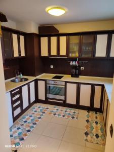 a kitchen with wooden cabinets and a sink at Апартамент ВалАнди in Samokov