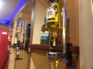 - un bar avec des bouteilles d'alcool sur le mur dans l'établissement Royal Hotel Apartments, à Kampala