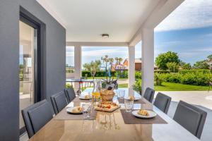 een eetkamer met een tafel en stoelen en een groot raam bij Villa Bella Vita by Istrabook in Rebići