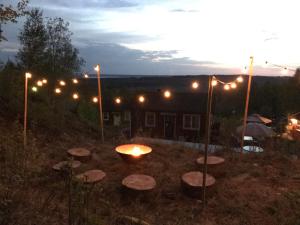 a fire pit in a yard at night with lights at Cozy Hilltop Cottage With Fantastic View in Undenäs