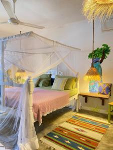 a bedroom with a bed with a canopy at FURAHA BEACH ROOMS in Kendwa