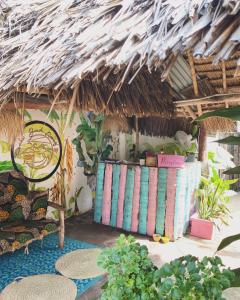 una habitación con plantas y techo de paja en FURAHA BEACH ROOMS en Kendwa