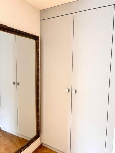 a mirror in a room with white closets at Luxury Studio Near UN & Train Station in Geneva