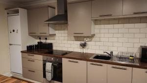 a kitchen with white cabinets and a sink at Large 2 Bed Holiday Let in Central Ystradgynlais in Ystradgynlais