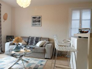 a living room with a couch and a glass table at Appartement design avec piscine in Digne-les-Bains