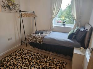 a bedroom with a leopard print bed and a window at Leopard in Dutton Warrington in Warrington