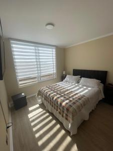 Un dormitorio con una cama grande y una ventana en Departamento La Serena por Días, en La Serena
