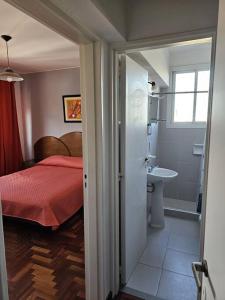 a bedroom with a bed and a bathroom with a sink at Alojamiento cómodo en el centro in Mendoza