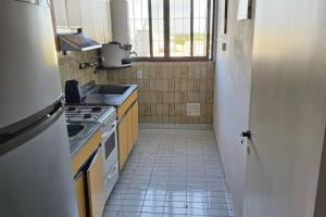 a small kitchen with a sink and a stove at Alojamiento cómodo en el centro in Mendoza +8 photos