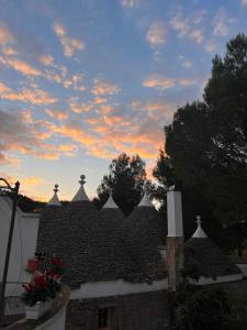 a roof of a house with a sunset in the background at Masseria Battaglini in Martina Franca