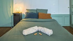 a bed with two pillows and two bottles on it at Chez Suzanne 0 - Chambre Privée dans Maison de Ville - Confort - Hypercentre in Troyes