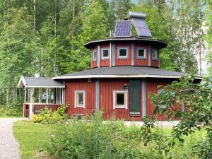 a red house with a solar panel on top of it at STF Växhuset Hostel in Bodarne