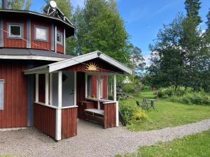 - un bâtiment rouge avec une terrasse couverte et une table dans l'établissement STF Växhuset Hostel, à Bodarne
