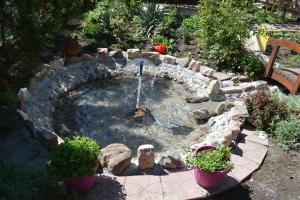 a small pond with a fountain in a garden at Studio Mini Lux in Požarevac