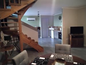 a living room with a staircase and a kitchen at GITE DE MONTRANCON in Landes