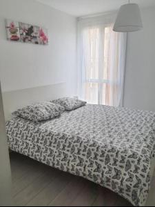 - une chambre avec un lit doté d'une couette et d'une fenêtre dans l'établissement Appartement la mer, à Marseille