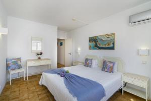 a bedroom with a large white bed with blue sheets at Rocha Oceanside by CC 925 in Portimão