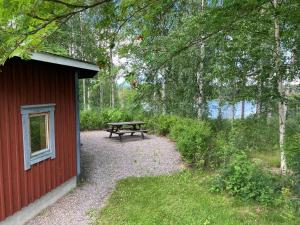a picnic table sitting next to a red building at STF Växhuset Hostel in Bodarne