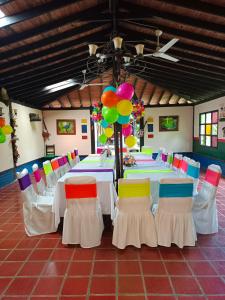 モンテネグロにあるAlojamiento rural finca estrella del Quindíoの長いテーブル、椅子、風船が備わる客室です。