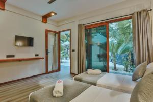 sala de estar con 2 camas y ventana grande en Hanyaa Island Maldives en Hangnaameedhoo