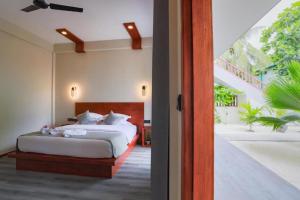 1 dormitorio con 1 cama y puerta abierta en Hanyaa Island Maldives en Hangnaameedhoo