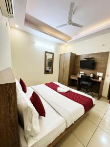 a bedroom with a large bed and a desk in it at Airport Park in New Delhi