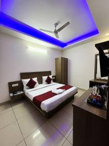a bedroom with a bed with a blue ceiling at Airport Park in New Delhi