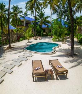 two chairs and a swimming pool on the beach at RoRi Private Luxury Villas in Bwejuu