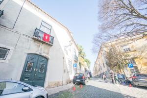 ein Gebäude mit grüner Tür an einer Stadtstraße in der Unterkunft Traditional Studio in Alfama in Lissabon