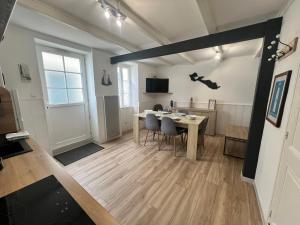 a living room with a table and a dining room at LE PHARE DE LA COTINIERE - Proche port et centre ville in La Flotte