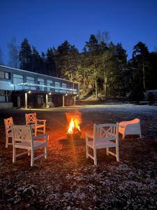 four chairs sitting around a fire in front of a building at R-Joki Apartments in Ravijoki