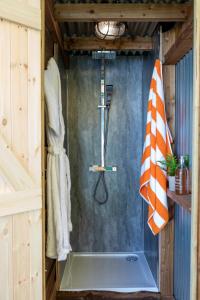 a shower in a bathroom with a glass shower stall at Orion 4-Person Lotus Belle Tent in Ross on Wye