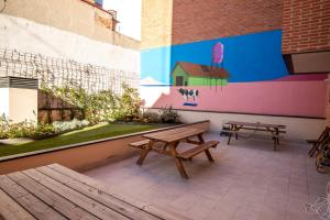 two benches and a mural on the side of a building at TX Matadero in Madrid