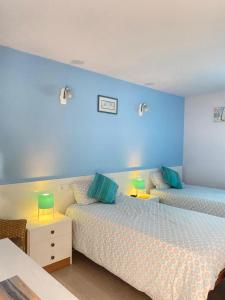 una camera con due letti e una parete blu di Cabedelo Seaside Guesthouse a Viana do Castelo