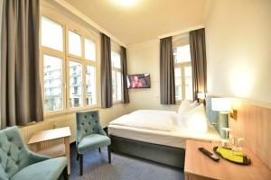 a hotel room with a bed and a desk and a chair at Hotel Meereseck in Bansin