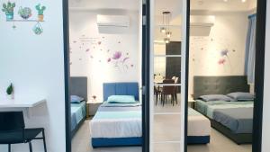 a bedroom with two beds and a table with a chair at Ocean Home@Urban Suites@12 Pax in Jelutong +58 photos
